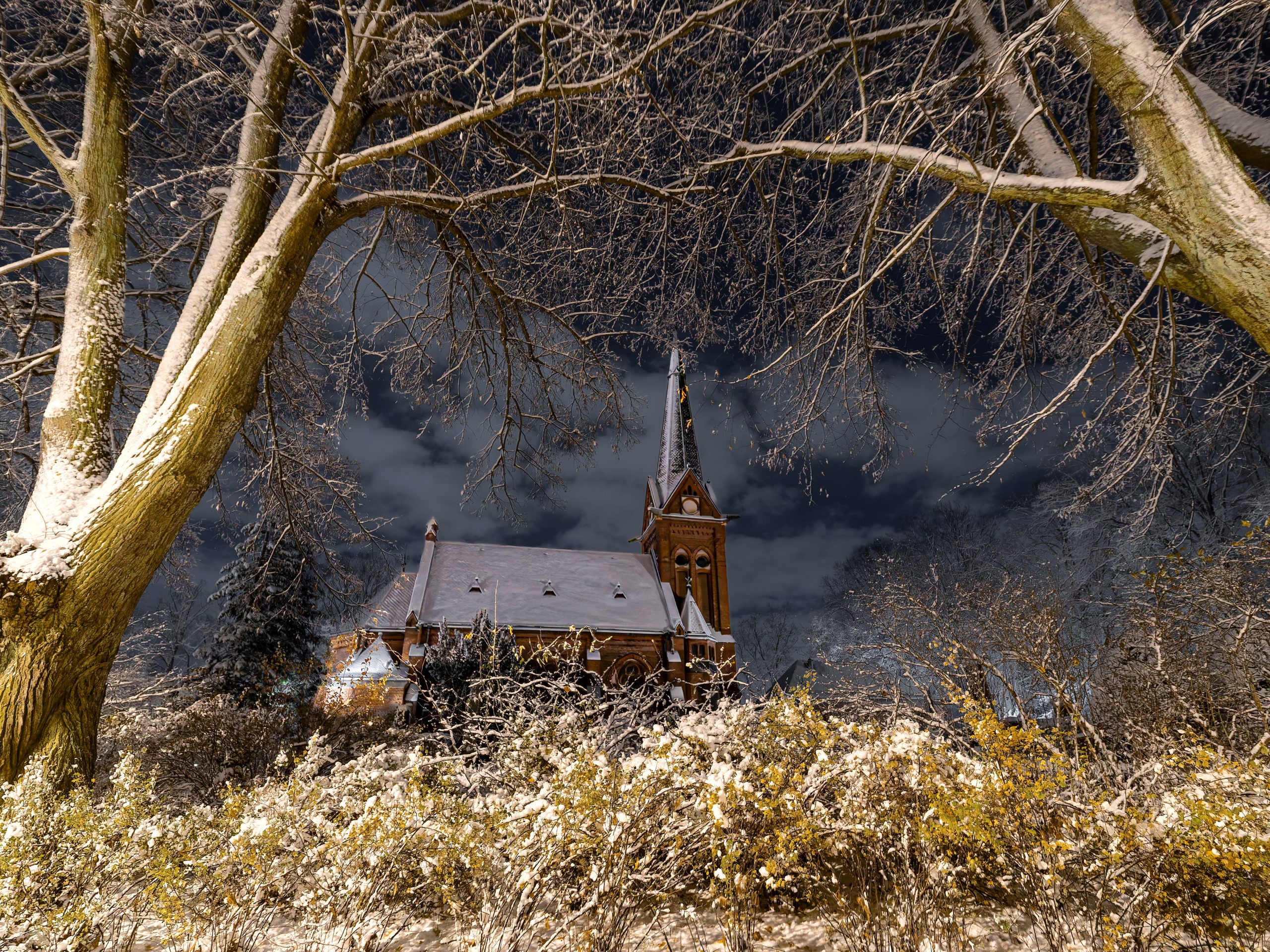 Kyrka på avstånd mellan två träd
