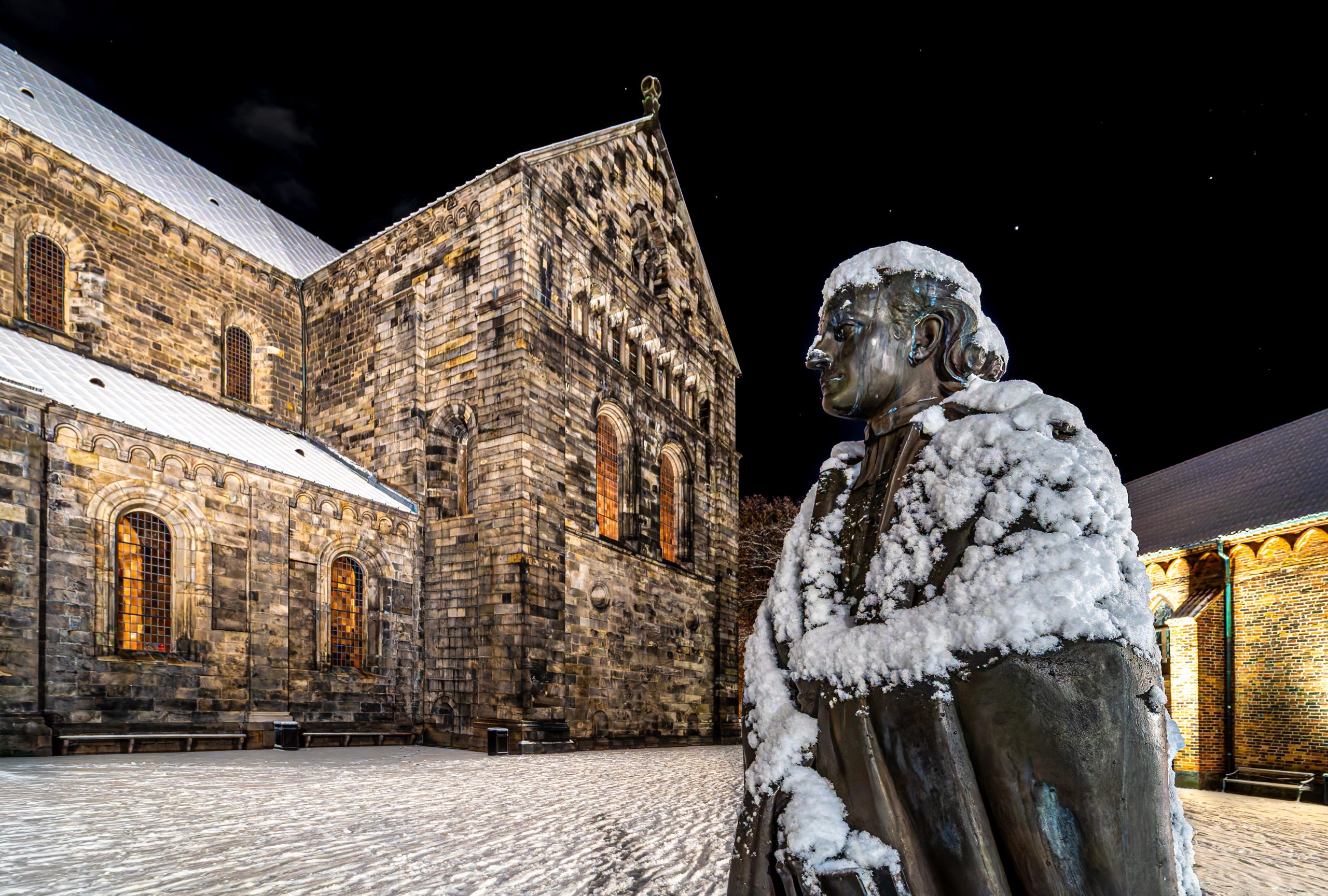 Staty av en man med lunds domkyrka i bakgrunden